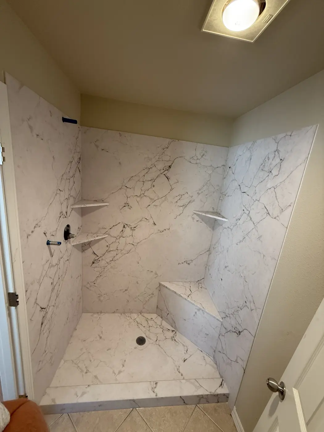 Marble-pattern walk-in shower with a built-in bench