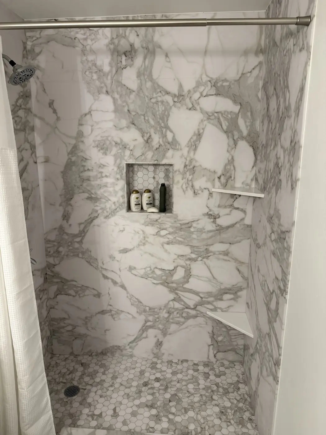 Custom shower with inset storage niche and mosaic floor