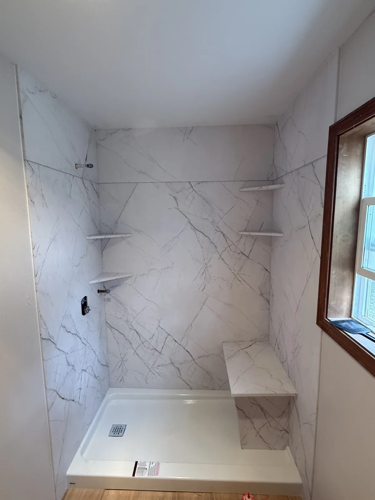 Walk-in shower with window and built-in seat